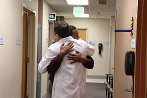 Kemal Hebano hugs Cyril Mauffrey Denver Health
