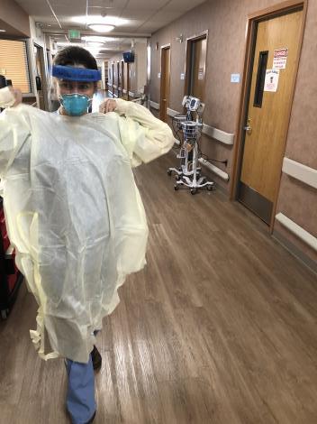 Denver Health Dr. Gaby Frank putting on PPE