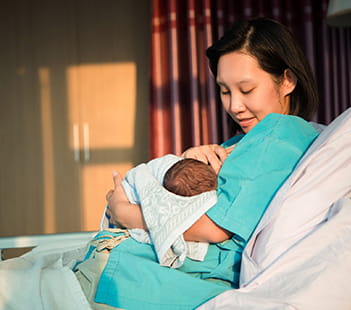 Woman breastfeeding National Breastfeeding Month Denver Health