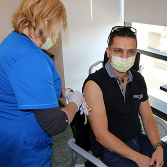 man getting flu shot during COVID-19 Denver Health