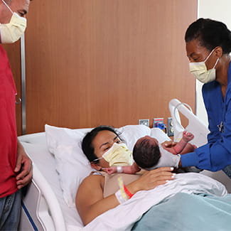 mom giving birth with nurse help at Denver Health