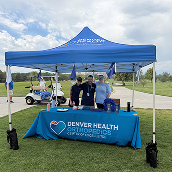 Denver Health representatives stand in front of a table at City Park Golf Course