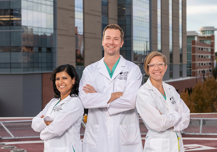 Three surgeons stand on the helipad at Denver Health