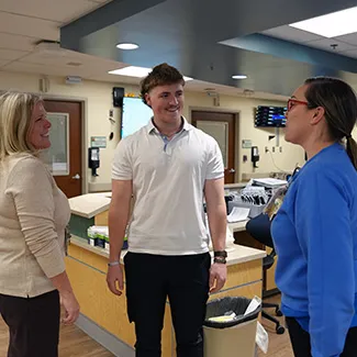 Denver Health patient Colin Metz stands in the Emergency Department at Denver Health with his mother and a nurse.