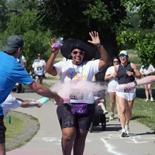 Garritte Hitchens runs through colored chalk at the Trauma Survivors Fun Run