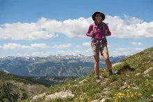 a hiker with a backpack stands on a mountain top