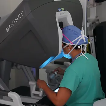 Denver Health bariatric surgeon Sany Thomas, MD, uses joysticks to control robotic arms for bariatric surgery.