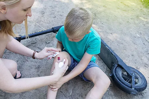 An iStock image of a mom helping a boy after a scooter crash.