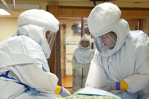 Members of Denver Health's High-risk Infection Team practice a drill in a simulated biocontainment unit.